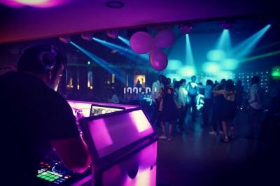 Un couple de mariés danse au milieu d'effets de fumée et d'étincelles dans une salle de réception décorée.