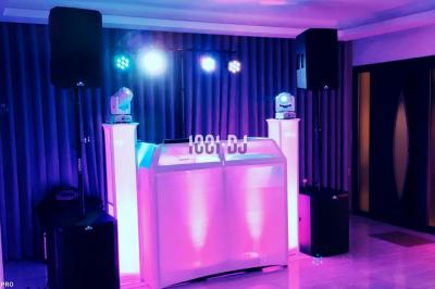 Un couple de mariés danse au milieu d'effets de fumée et d'étincelles dans une salle de réception décorée.