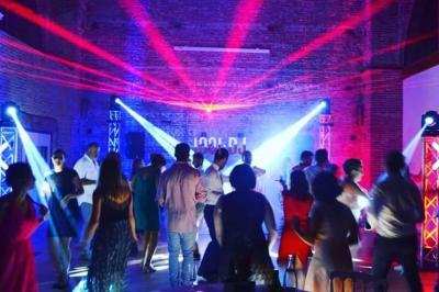 Un couple de mariés danse au milieu d'effets de fumée et d'étincelles dans une salle de réception décorée.