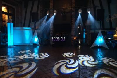 Un couple de mariés danse au milieu d'effets de fumée et d'étincelles dans une salle de réception décorée.