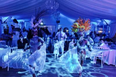 Un couple de mariés danse au milieu d'effets de fumée et d'étincelles dans une salle de réception décorée.