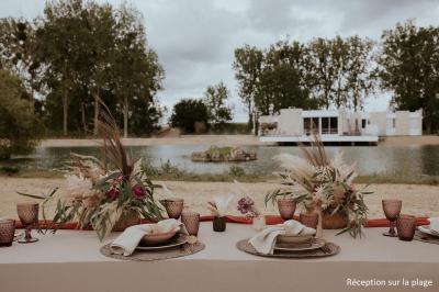 Vue aérienne d'un parc avec plusieurs étangs, espaces verts, chemins et bâtiments entourés de végétation.