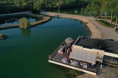 Vue aérienne d'un parc avec plusieurs étangs, espaces verts, chemins et bâtiments entourés de végétation.