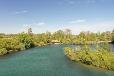 Vue aérienne d'un parc avec plusieurs étangs, espaces verts, chemins et bâtiments entourés de végétation.