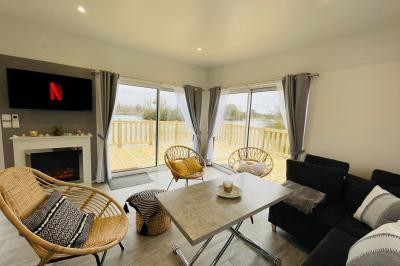 Vue aérienne d'un parc avec plusieurs étangs, espaces verts, chemins et bâtiments entourés de végétation.