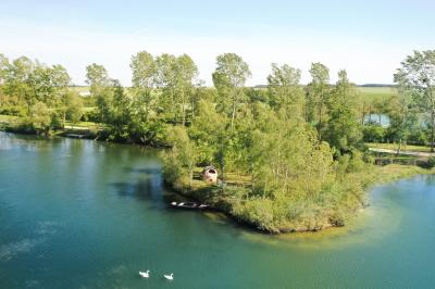Vue aérienne d'un parc avec plusieurs étangs, espaces verts, chemins et bâtiments entourés de végétation.