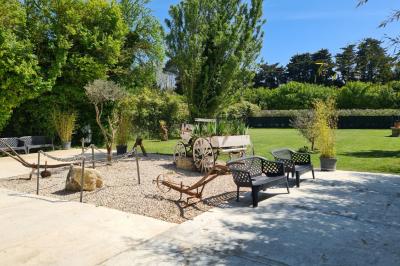 Salle vide avec un sol en parquet sombre, murs blancs, fenêtres et piliers gris sous un plafond à dalles blanches.
