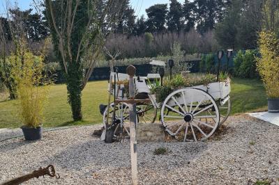 Salle vide avec un sol en parquet sombre, murs blancs, fenêtres et piliers gris sous un plafond à dalles blanches.