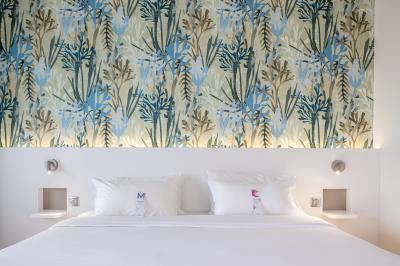 Salle de restaurant moderne avec tables en bois dressées, chaises rembourrées et lumière naturelle.
