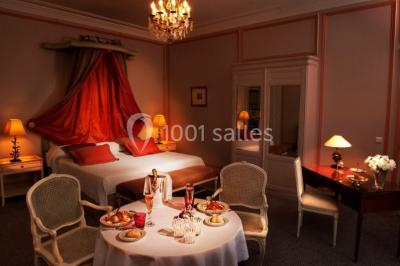 Façade d'un bâtiment blanc avec une enseigne ’Pavillon Henri IV Restaurant’, entouré de verdure et d'une clôture.