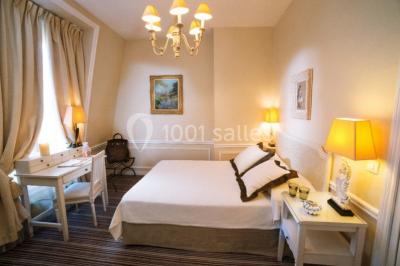 Façade d'un bâtiment blanc avec une enseigne ’Pavillon Henri IV Restaurant’, entouré de verdure et d'une clôture.