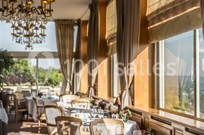 Façade d'un bâtiment blanc avec une enseigne ’Pavillon Henri IV Restaurant’, entouré de verdure et d'une clôture.