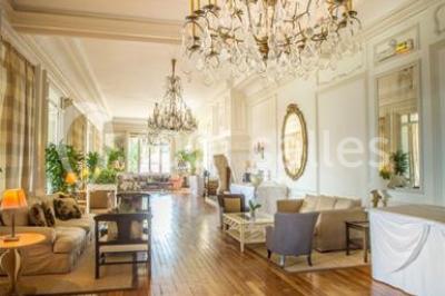 Façade d'un bâtiment blanc avec une enseigne ’Pavillon Henri IV Restaurant’, entouré de verdure et d'une clôture.