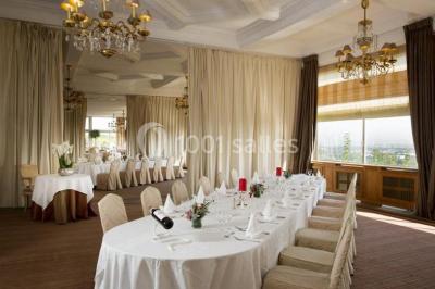 Façade d'un bâtiment blanc avec une enseigne ’Pavillon Henri IV Restaurant’, entouré de verdure et d'une clôture.