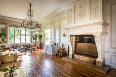Façade d'un bâtiment blanc avec une enseigne ’Pavillon Henri IV Restaurant’, entouré de verdure et d'une clôture.