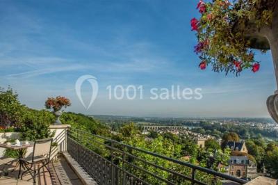 Façade d'un bâtiment blanc avec une enseigne ’Pavillon Henri IV Restaurant’, entouré de verdure et d'une clôture.