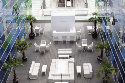Salle de bain moderne avec douche à l'italienne, carrelage à motifs noirs et blancs, lavabo et miroir éclairé.