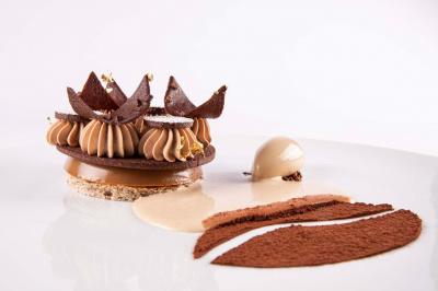 Intérieur d'un salon moderne avec un bureau blanc, des étagères éclairées, des décorations élégantes et un coin salon.