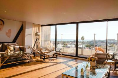 Intérieur d'un salon moderne avec un bureau blanc, des étagères éclairées, des décorations élégantes et un coin salon.