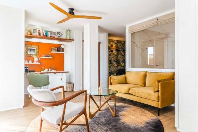 Intérieur d'un salon moderne avec un bureau blanc, des étagères éclairées, des décorations élégantes et un coin salon.