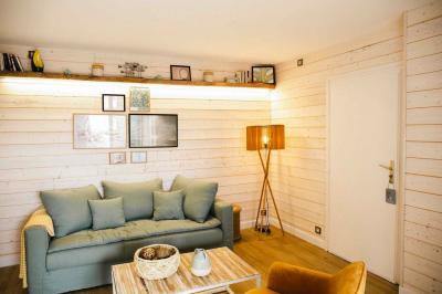 Intérieur d'un salon moderne avec un bureau blanc, des étagères éclairées, des décorations élégantes et un coin salon.