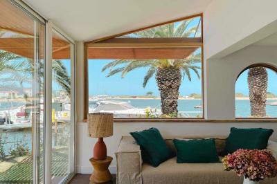 Intérieur d'un salon moderne avec un bureau blanc, des étagères éclairées, des décorations élégantes et un coin salon.