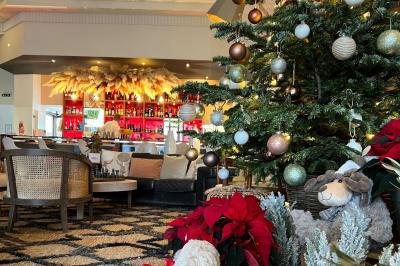 Intérieur d'un salon moderne avec un bureau blanc, des étagères éclairées, des décorations élégantes et un coin salon.