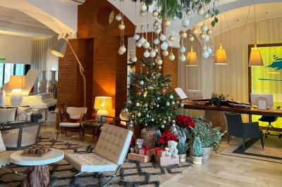 Intérieur d'un salon moderne avec un bureau blanc, des étagères éclairées, des décorations élégantes et un coin salon.