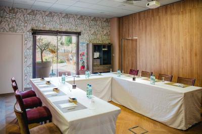 Intérieur d'un salon moderne avec un bureau blanc, des étagères éclairées, des décorations élégantes et un coin salon.