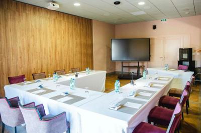 Intérieur d'un salon moderne avec un bureau blanc, des étagères éclairées, des décorations élégantes et un coin salon.