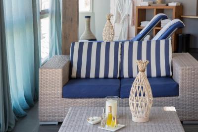 Terrasse ensoleillée avec tables et chaises bleues, décorée de plantes et d'un panneau indiquant ’La plage’.
