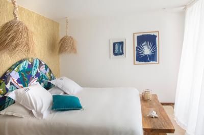 Terrasse ensoleillée avec tables et chaises bleues, décorée de plantes et d'un panneau indiquant ’La plage’.