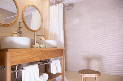 Terrasse ensoleillée avec tables et chaises bleues, décorée de plantes et d'un panneau indiquant ’La plage’.