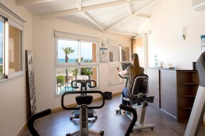 Terrasse ensoleillée avec tables et chaises bleues, décorée de plantes et d'un panneau indiquant ’La plage’.