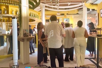 Un couple danse entouré d'invités dans une salle éclairée par des lumières colorées, avec un DJ en arrière-plan.