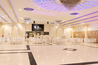 Salle de conférence lumineuse avec tables disposées en U, chaises noires et un tableau noir au fond.