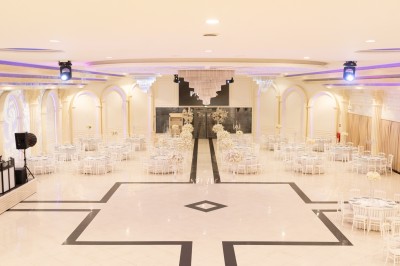 Salle de conférence lumineuse avec tables disposées en U, chaises noires et un tableau noir au fond.