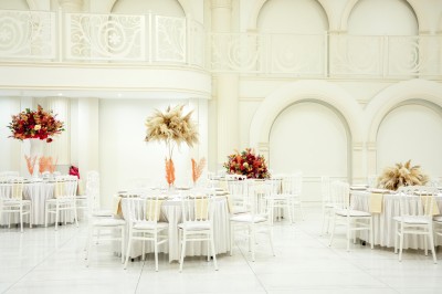 Salle de conférence lumineuse avec tables disposées en U, chaises noires et un tableau noir au fond.