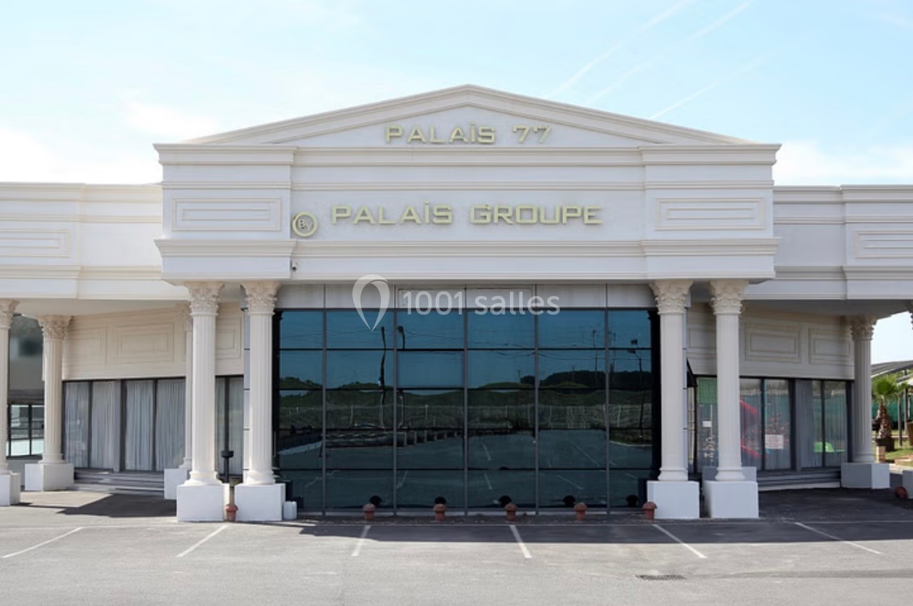 Façade d'un bâtiment blanc avec des colonnes et des inscriptions ’Palais 77’ et ’Palais Groupe’ sur le fronton.
