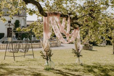 Un couple de mariés s'embrasse devant des invités applaudissant dans une salle de réception lumineuse.