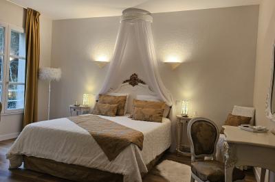 Un couple de mariés s'embrasse devant des invités applaudissant dans une salle de réception lumineuse.