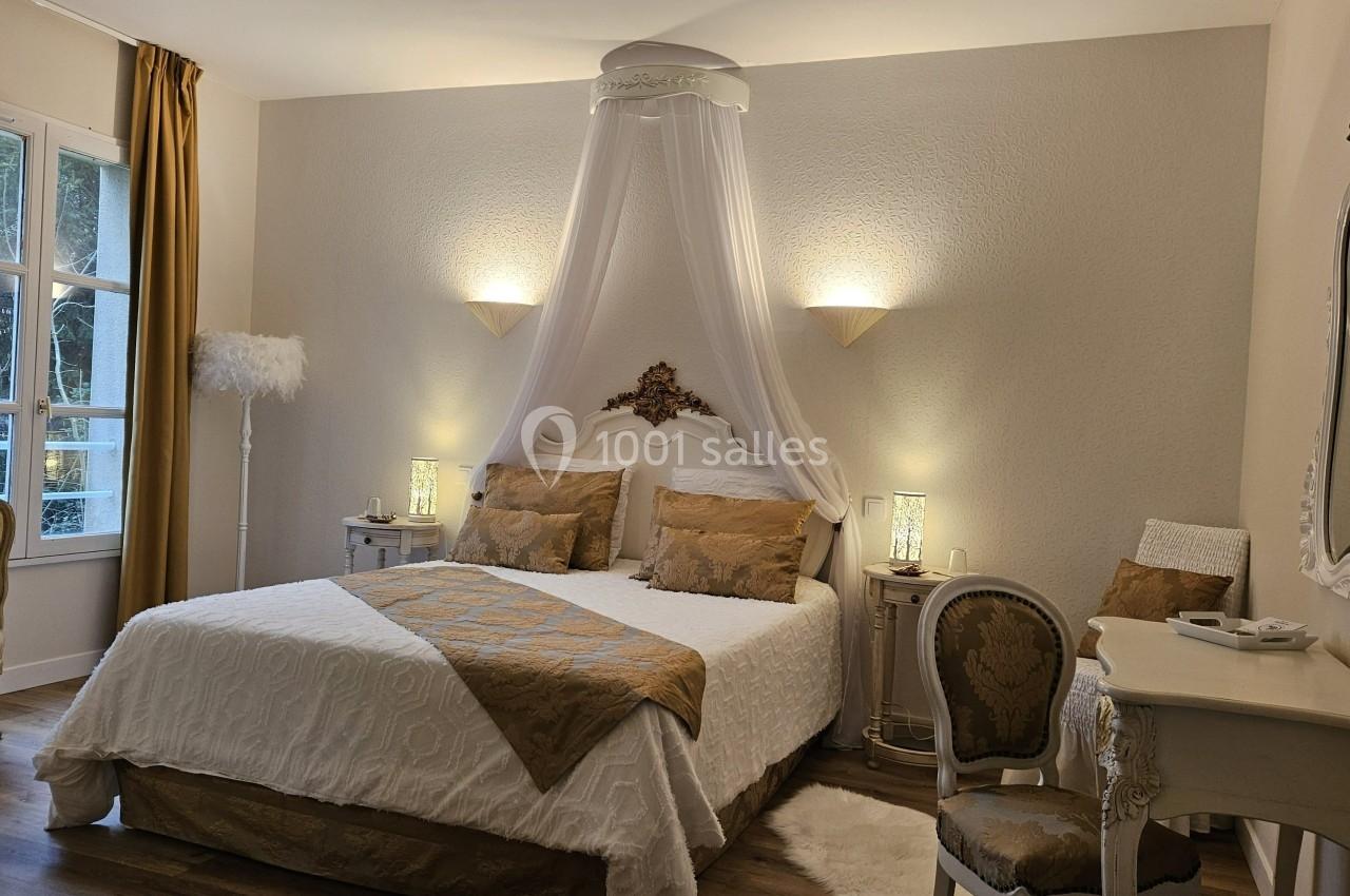 Chambre élégante avec lit double, baldaquin blanc, mobilier classique et lumière douce, vue sur une fenêtre.