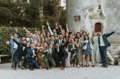 Un couple de mariés s'embrasse devant des invités applaudissant dans une salle de réception lumineuse.