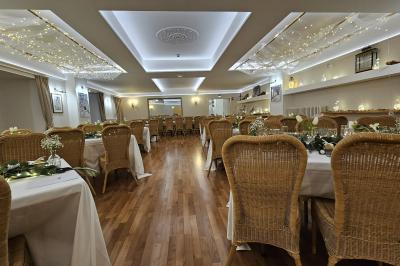 Un couple de mariés s'embrasse devant des invités applaudissant dans une salle de réception lumineuse.