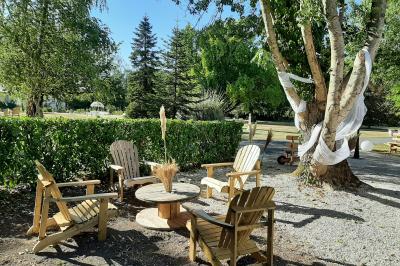 Un couple de mariés s'embrasse devant des invités applaudissant dans une salle de réception lumineuse.