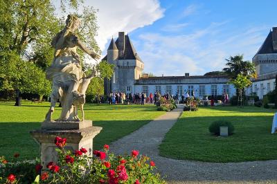 Un couple de mariés s'embrasse devant des invités applaudissant dans une salle de réception lumineuse.