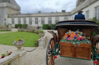 Un couple de mariés s'embrasse devant des invités applaudissant dans une salle de réception lumineuse.