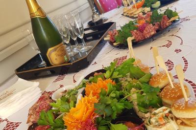 Des personnes en costumes d'époque discutent dans la cour d'un château historique sous un ciel partiellement nuageux.