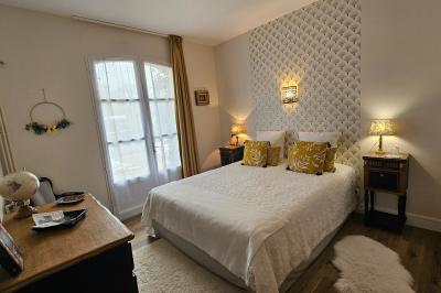 Des personnes en costumes d'époque discutent dans la cour d'un château historique sous un ciel partiellement nuageux.