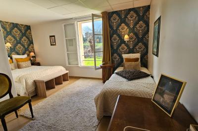 Des personnes en costumes d'époque discutent dans la cour d'un château historique sous un ciel partiellement nuageux.